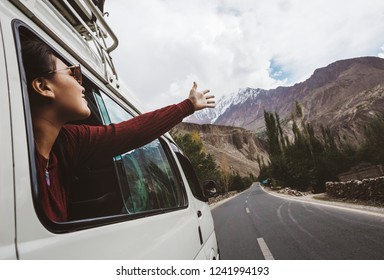 Woman enjoying the cool breeze from the car window