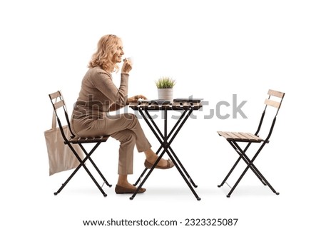 Woman enjoying a cup of coffee and sitting at a table alone isolated on white background