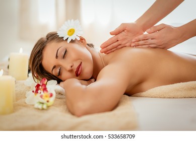 Woman enjoying during a back massage at a spa. 