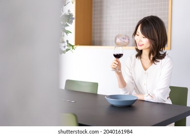 A woman enjoying a glass of wine at a restaurant