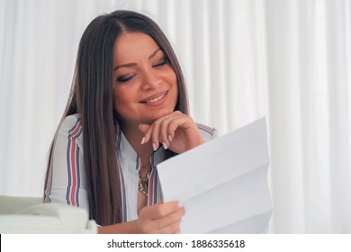 Woman enjoying good news in writing. An euphoric female is happy after reading good news in a written letter, approving a loan