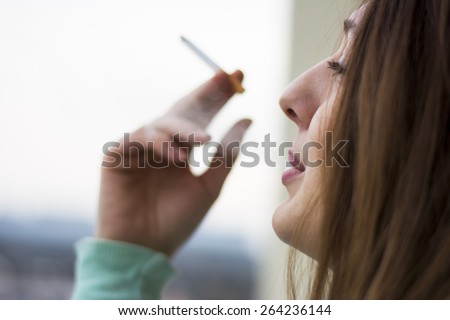 Woman enjoying her cigarette in the morning on the terrace