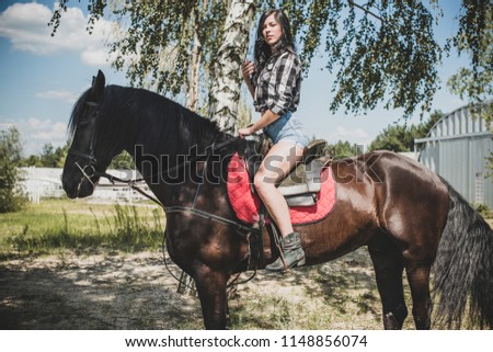 Woman enjoying horse company. Young Beautiful Woman dressed plaid shirt With black Horse Outdoors, stylish girl at american country style