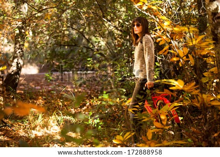 Woman with a bike in the middle of the forest.