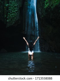 Woman Enjoying Open Arms Face The Near Hidden In Jungle Cascade Waterfall In Bali. Body And Black Swimsuit, Fashion Model. Asian Model
