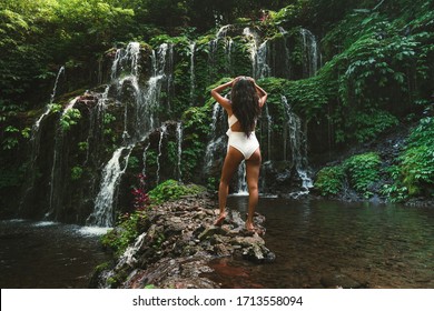 Woman Enjoying Open Arms Face The Near Hidden In Jungle Cascade Waterfall In Bali. Body And Black Swimsuit, Fashion Model. Asian Model
