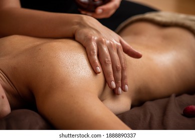 Woman enjoying relaxing back massage in cosmetology spa centre. Body care, skin care, wellness, wellbeing, beauty treatment concept.
