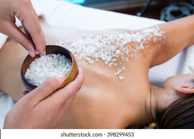 Woman Enjoying A Salt Scrub Massage At Spa