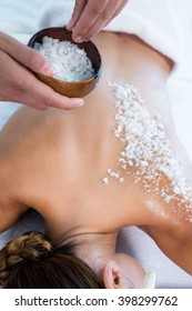 Woman Enjoying A Salt Scrub Massage At Spa