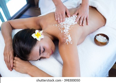 Woman Enjoying A Salt Scrub Massage At Spa