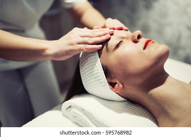 Woman enjoying skin and face treatment and massage - Shutterstock ID 595768982