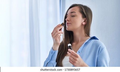 Woman enjoying the smell of herbal essential perfume oil for aromatherapy, beauty skin care and natural medicine 