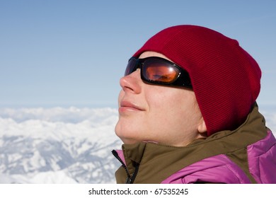 Woman Enjoying Sun In Winter On Summit In Alps