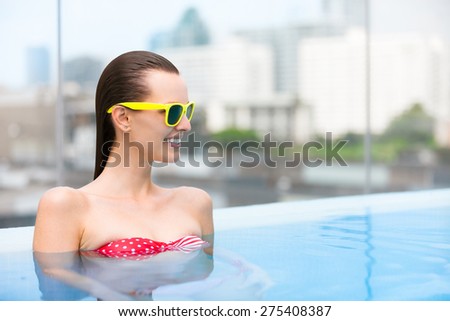 Woman enjoying a swim in a luxurious pool.