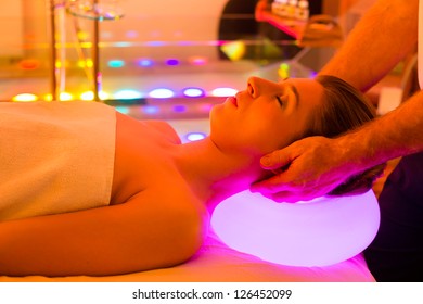 Woman enjoying therapy in spa with color therapy, colorful lights stimulating the psyche