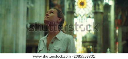 Woman enjoying view of architecture in the cathedral church. Girl face close-up looking up at antique ceiling.