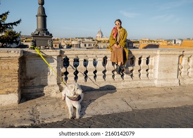 Woman Enjoys Beautiful Cityscape Of Old Rome City, Standing Back With Her Dog On The Top Of Spanish Steps In The Morning. Concept Of Italian Lifestyle And Travel