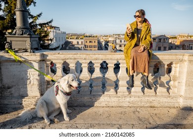 Woman Enjoys Beautiful Cityscape Of Old Rome City, Standing Back With Her Dog On The Top Of Spanish Steps In The Morning. Concept Of Italian Lifestyle And Travel