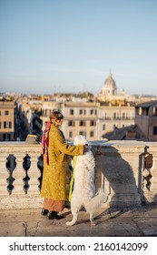 Woman Enjoys Beautiful Cityscape Of Old Rome City, Standing Back With Her Dog On The Top Of Spanish Steps In The Morning. Concept Of Italian Lifestyle And Travel