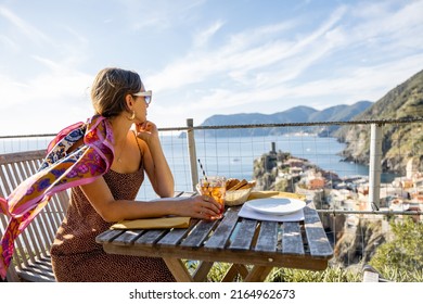 Woman Enjoys Beautiful Landscape Of Coastline With Old Vernazza Village, Traveling In Famous Cinque Terre Region In Northwestern Italy. Idea Of Mediterranean Food And Lifestyle