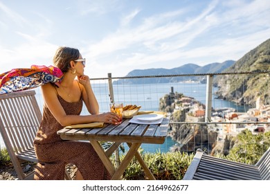 Woman Enjoys Beautiful Landscape Of Coastline With Old Vernazza Village, Traveling In Famous Cinque Terre Region In Northwestern Italy. Idea Of Mediterranean Food And Lifestyle