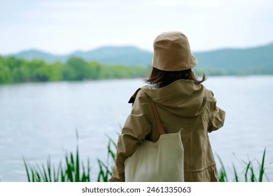 Woman Enjoys Peaceful Lakeside Solitude - Powered by Shutterstock