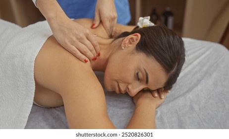 A woman enjoys a relaxing massage by a therapist in an indoor spa, highlighting wellness, relaxation, and self-care. - Powered by Shutterstock