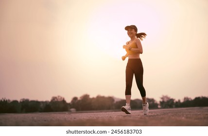 woman enjoys running outside on sunset. Summer sport and freedom concept. Athlete training on dusk. - Powered by Shutterstock