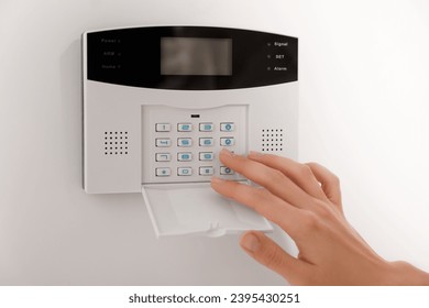 Woman entering code on home security system, closeup - Shutterstock ID 2395430251