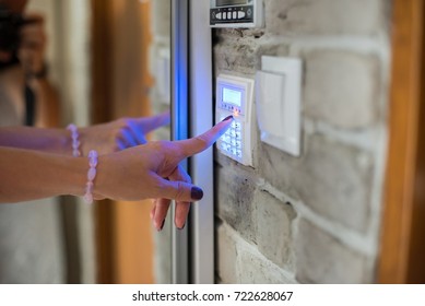 Woman Entering Password On Home Alarm Keypad. Home Security System.