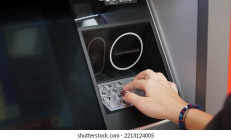 A Woman Entering Pin Number For Bank ATM Machine	