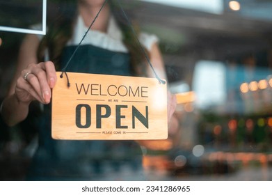 Woman entrepreneur with Open sign in cafe shop , small business concept  - Powered by Shutterstock