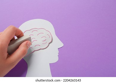 Woman Erasing Brain On Human Head Paper Cutout On Violet Background, Top View With Space For Text. Dementia Concept