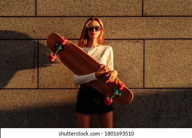 A woman in the evening city rides a longboard. High quality photo - Powered by Shutterstock