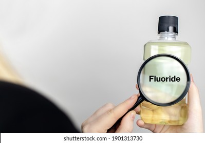 A Woman Examines The Harmful Ingredients Of The Mouthwash. Harmful Composition Of Ingredients. Rinse Aid With Fluoride.