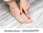 woman examining the horn on her big toe. nail fungus. toenail disease. onychomycosis of nails. yellow toenail. change in nail color. treatment of toenail disease. problem toenails