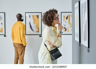 Woman examining modern art at gallery - Shutterstock ID 2213188907