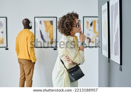 Woman examining modern art at gallery