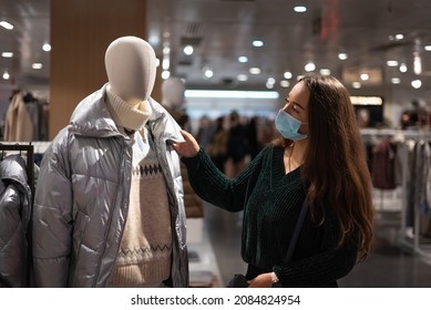 Woman examining outerwear on dummy
