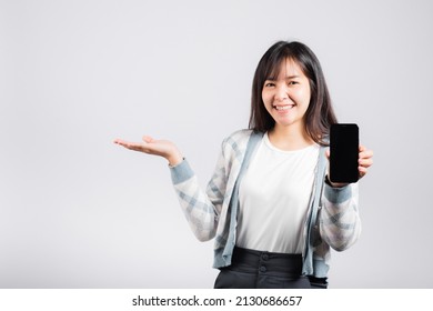 Woman Excited Holding Mobile Phone Blank Screen Presenting Product With Palm Of Hand At Empty Studio Shot Isolated White Background, Happy Young Female Smiling Gesture Show Something Product