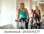 Woman, exercise bike and gym for performance, training and cycling for fitness or spin class. Female person, riding and stationary machine for workout challenge, aerobic instructor and equipment