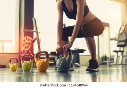 Woman exercise workout at gym fitness training sport with kettlebells weight lifting and legs squat healthy lifestyle bodybuilding.