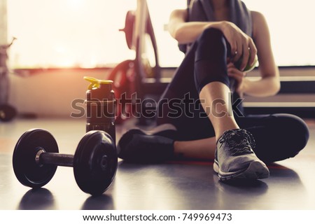 Woman exercise workout in gym fitness breaking relax holding apple fruit after training sport with dumbbell and protein shake bottle healthy lifestyle bodybuilding, Athlete builder muscles lifestyle. Stock foto © 