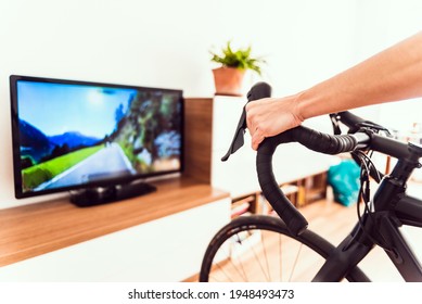 Woman Exercises Indoors Using Her Bike For A Virtual Race.