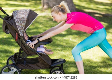 Woman exercising with baby stroller in park - Powered by Shutterstock