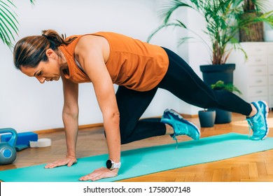 Woman Exercising, Doing Mountain Climbers, HIIT Or High Intensity Interval Training At Home