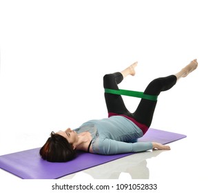 Woman exercising doing postnatal workout. Female fitness instructor working out with a rubber resistance band isolated on white background  