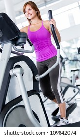 Woman Exercising At The Gym On A Cross Trainer