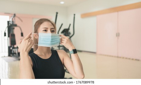 Woman Exercising In Gym Wearing Face Mask