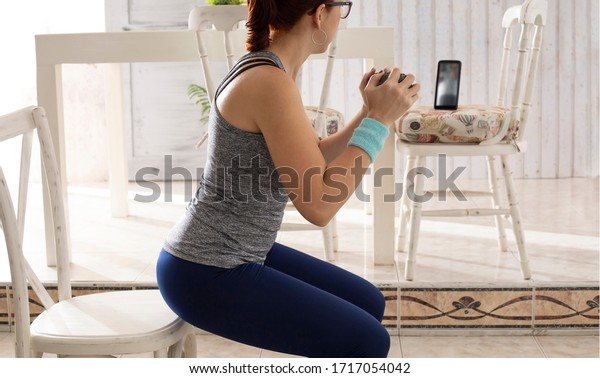 woman exercising with hand weights in conference call from cellphone stay at home concept